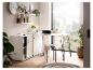 Bureau blanc avec rangement, ordinateur portable, plantes et vue sur la ville.