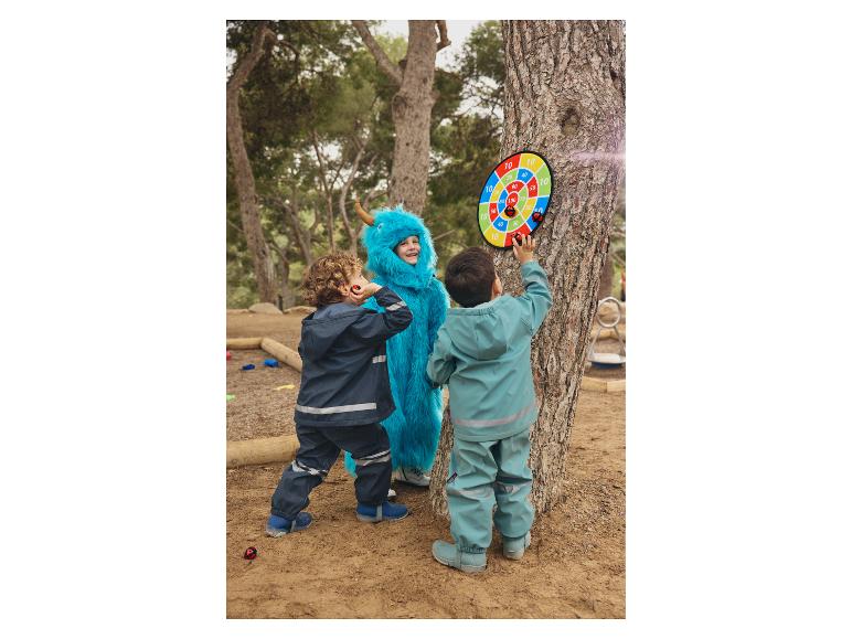 Des enfants jouent aux fléchettes en plein air.