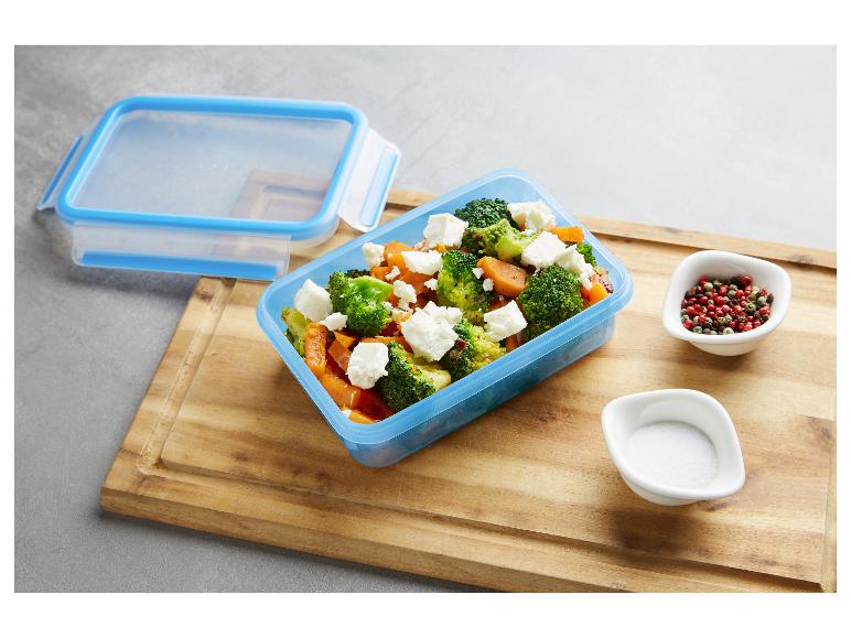 Boîte alimentaire bleue avec salade de brocoli et patate douce à la feta, sel et poivre.