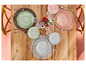 Trois ensembles de plats, couverts et dessous de plats sur une table en bois.