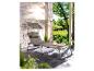 Une chaise longue beige avec un parasol sur une terrasse.