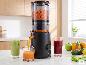 Extracteur de jus SILVERCREST® Premium SSJBM 400 D1 versant du jus d'orange frais dans un verre