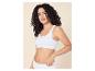 Femme aux cheveux bouclés portant une brassière côtelée blanche et une culotte assortie.