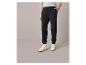 Pantalon de survêtement noir avec des baskets blanches.