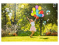 Une fille avec des ballons de couleurs et des bulles dans un parc.