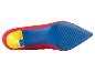 Le dessous d'une chaussure en daim rouge avec un talon bleu et une semelle jaune.