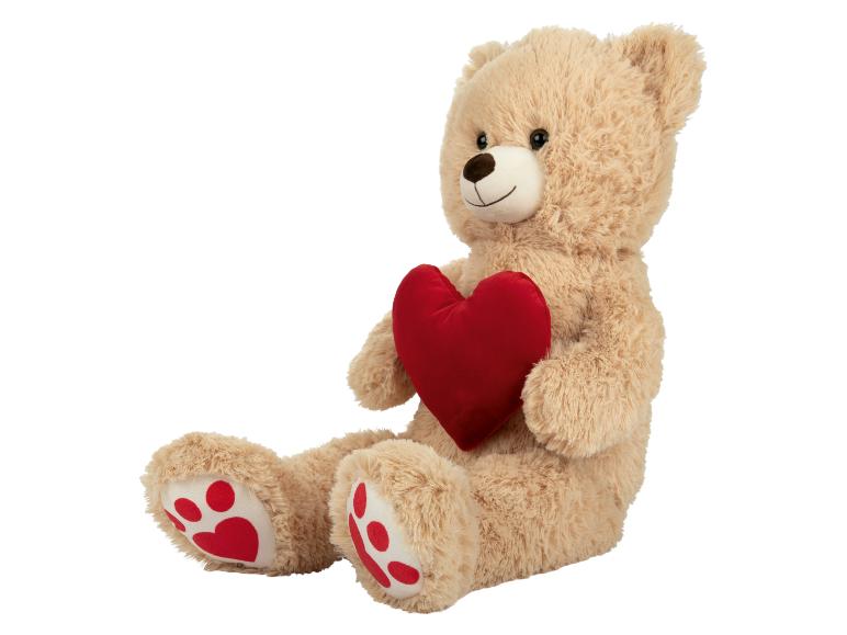 Un ours en peluche tenant un cœur rouge.