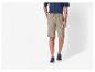 Un homme portant un short beige et des baskets bleues.