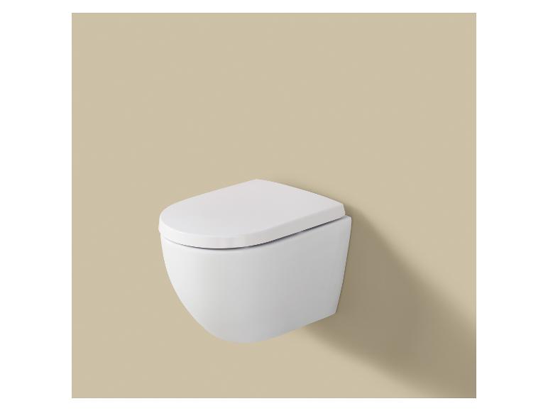 Des toilettes blanches suspendues avec un couvercle fermé sur un mur beige.