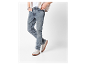 Homme en cardigan beige clair et jeans bleus avec baskets beiges.