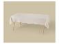 Table rectangulaire avec une nappe beige clair sur un fond assorti.