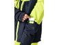 Veste de ski bleu marine et jaune fluo avec une carte dans la poche de la manche.