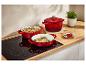 Trois cocottes Le Creuset rouges sur une plaque à induction.