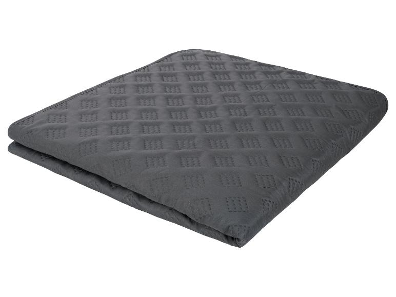 Couverture grise matelassée, motif géométrique.