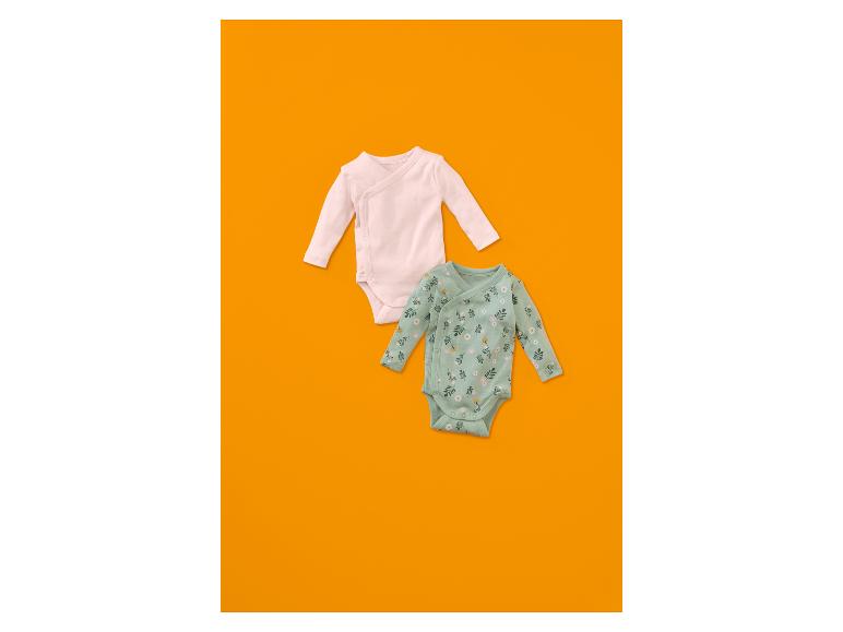 Deux bodies pour bébé, un rose pâle et un vert menthe à motif floral.