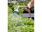 Un arroseur de jardin arrose des plantes avec de l'eau.