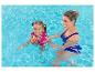 Mère et enfant souriants dans une piscine, l'enfant portant un gilet de natation rose.