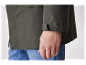 Gros plan sur le poignet d'une veste vert olive foncé avec un bouton.