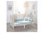 Lit bébé blanc avec literie bleu clair et images enfantines au mur.