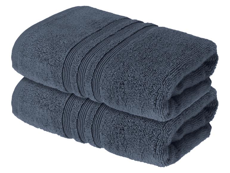 Deux serviettes de bain bleu foncé pliées en tissu éponge