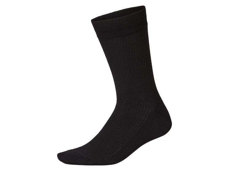 Une chaussette noire simple et côtelée placée verticalement sur un fond blanc.