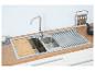 Évier de cuisine en acier inoxydable avec planche à découper en bois et égouttoir.
