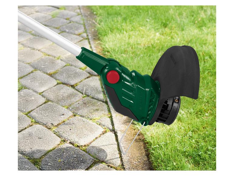 Coupe-bordures près d'un chemin pavé, avec de l'herbe sur le côté