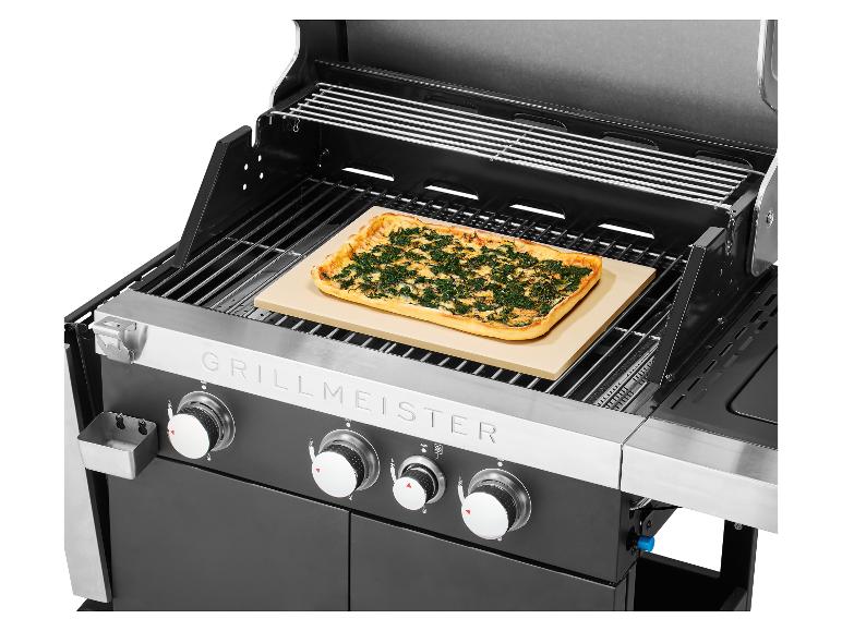 Barbecue à gaz avec pizza sur pierre de cuisson, boutons de commande visibles