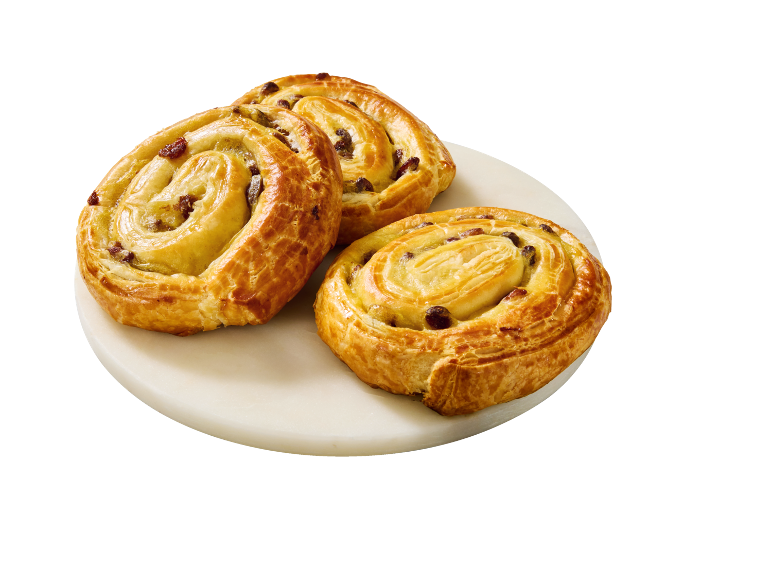 Trois pains aux raisins dorés sur une assiette en marbre blanc