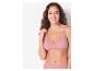 Une femme porte une bralette rose avec des détails en dentelle.