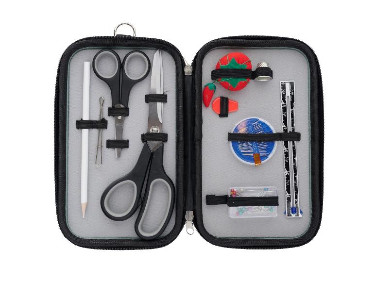 Trousse de couture ouverte avec ciseaux, aiguilles, dé à coudre et outils de mesure.