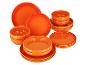 Ensemble d'assiettes et de bols orange de différentes tailles, empilés sur fond blanc.
