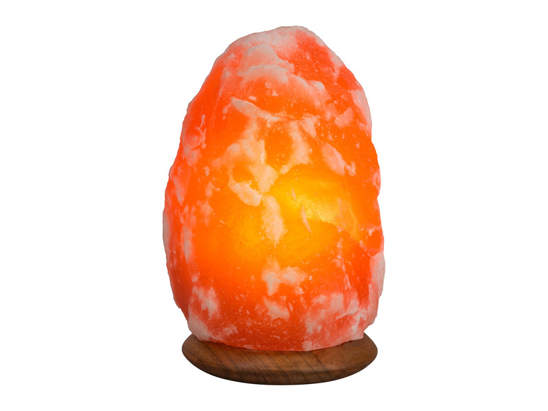 Une lampe en sel orange sur un socle en bois.