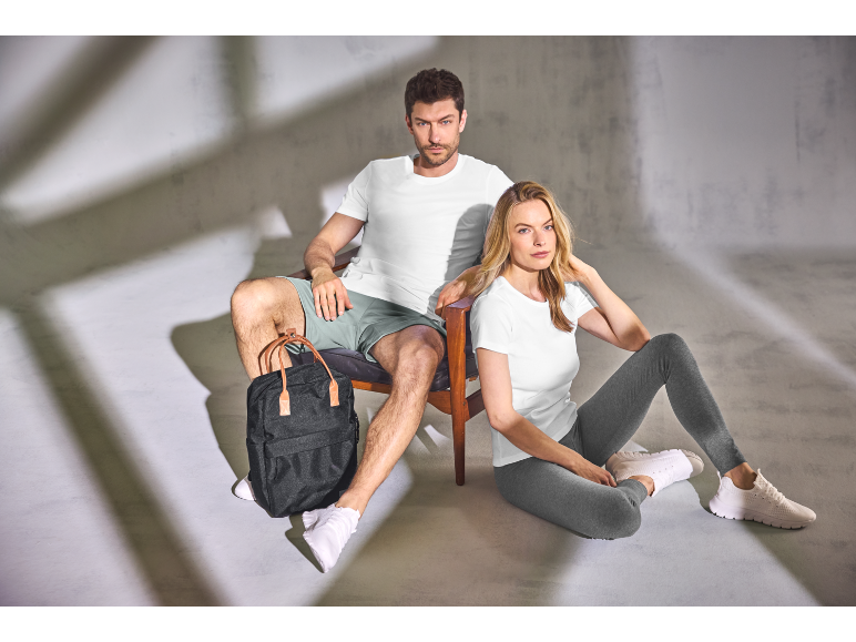 Homme et femme en tenue de sport avec un sac à dos noir.