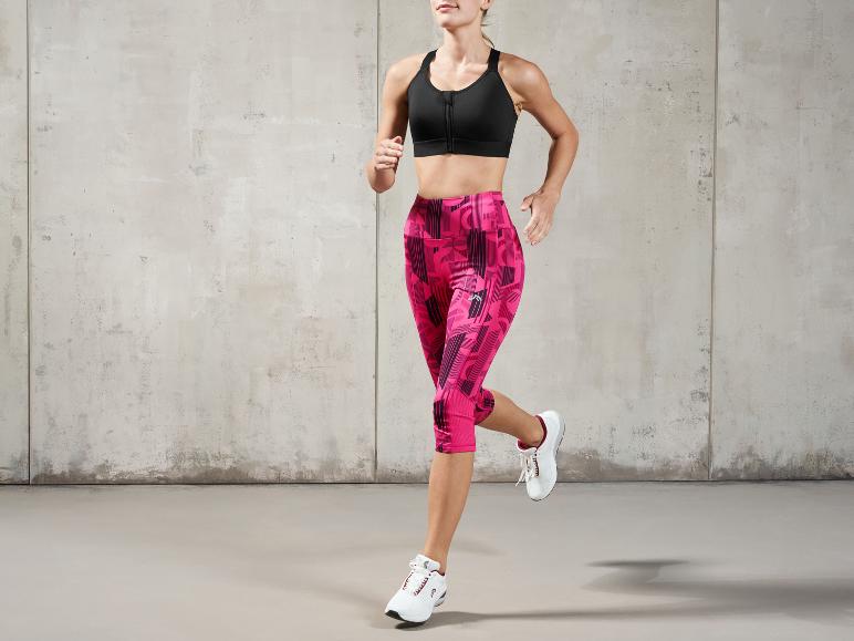 Une femme en soutien-gorge de sport et leggings court en chaussures de sport.