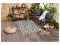 Tapis d'extérieur gris à motif géométrique, salon de jardin et accessoires.