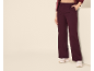 Femme portant un pantalon large bordeaux élégant et des baskets blanches