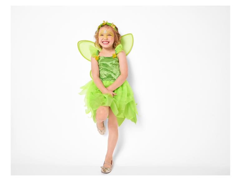 Fillette souriante en costume de fée verte avec des ailes et du maquillage.