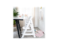 Chaise haute en bois blanc à côté d'une table avec vaisselle pour bébé dans une pièce lumineuse.