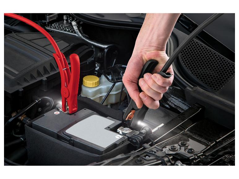 Mains connectant des câbles de démarrage à une batterie de voiture.