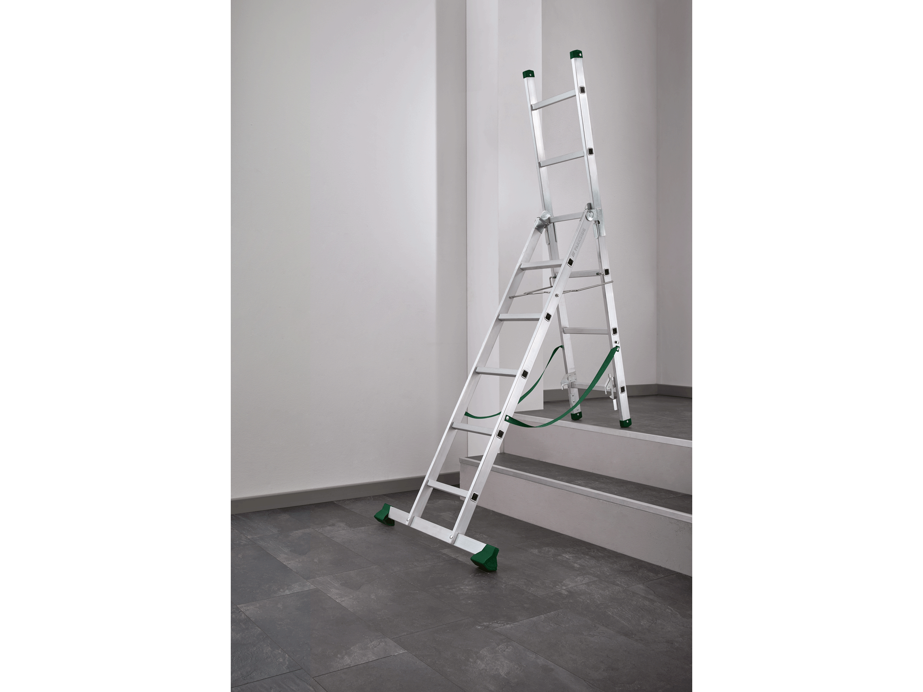 Échelle en aluminium pliable près d'un escalier.