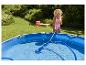 Nettoyage d'une piscine hors-sol avec un aspirateur manuel.