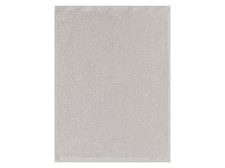 Une serviette de bain en éponge de couleur gris clair.