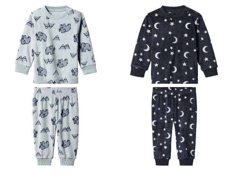 Deux ensembles de pyjamas pour enfants, l'un avec des éléphants et des montagnes, l'autre avec des étoiles et des lunes.