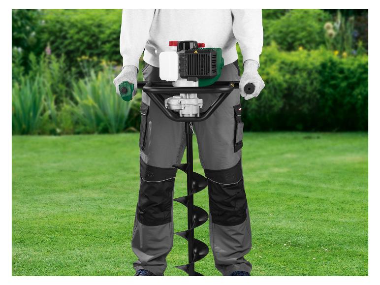 Homme utilisant une tarière thermique pour le jardinage sur une pelouse verte.