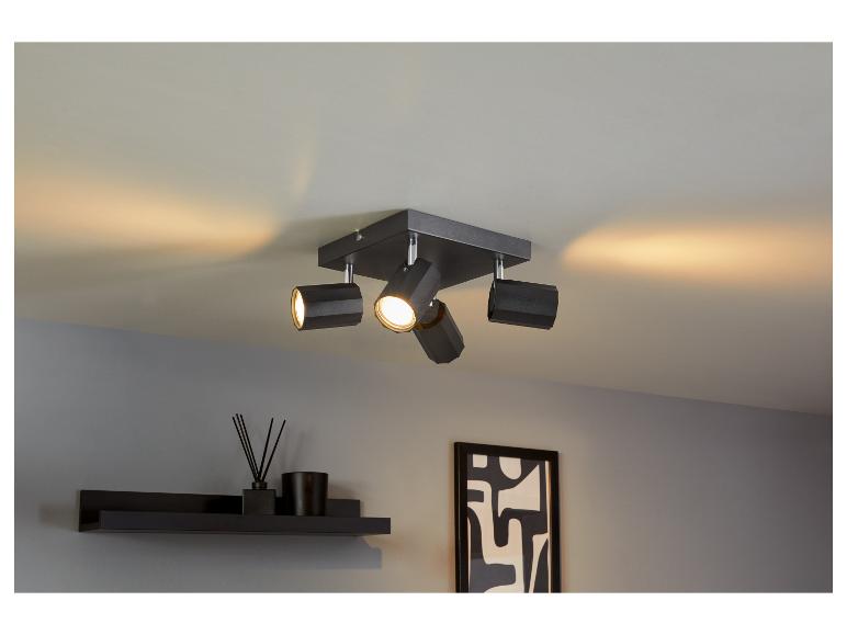 Spot de plafond noir avec quatre lampes.