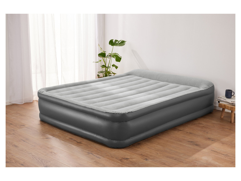 Un matelas pneumatique gris sur un sol en bois.