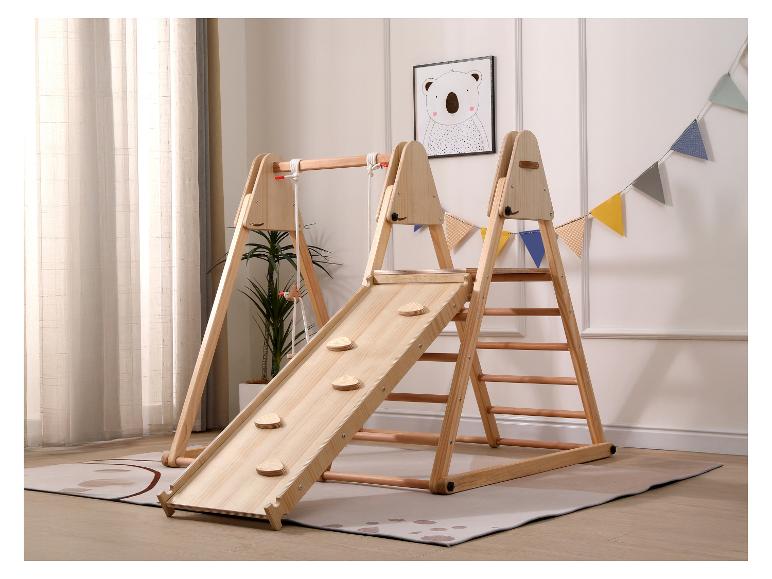 Aire de jeux intérieure en bois avec toboggan, mur d'escalade et balançoire dans une chambre d'enfant