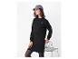 Femme en robe sweat noire, casquette grise et collants noirs, avec une chaise.