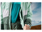 Une veste verte avec une bande blanche et vert clair, sur un pantalon vert foncé.